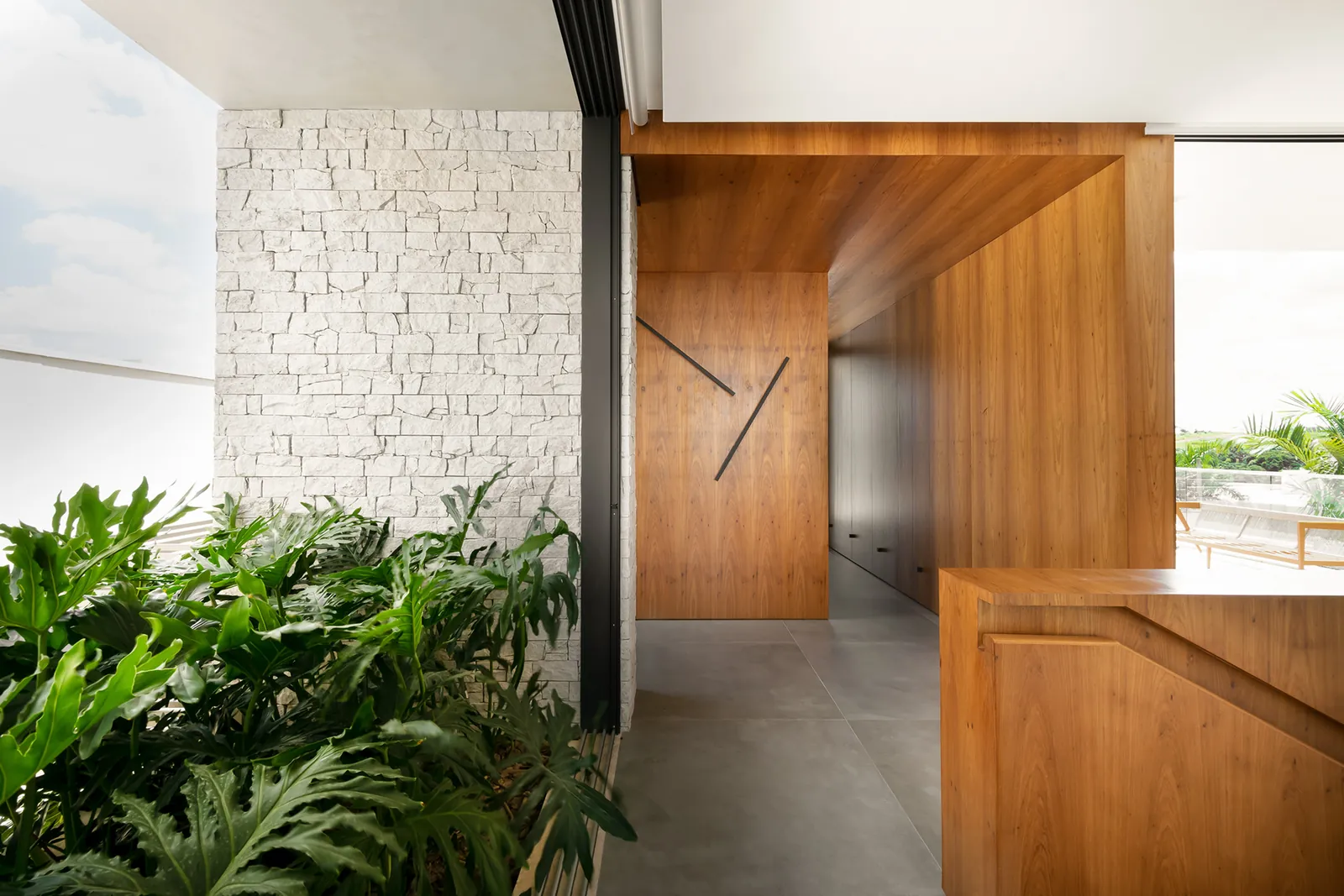 Hall com porta de madeira, pedra e plantas