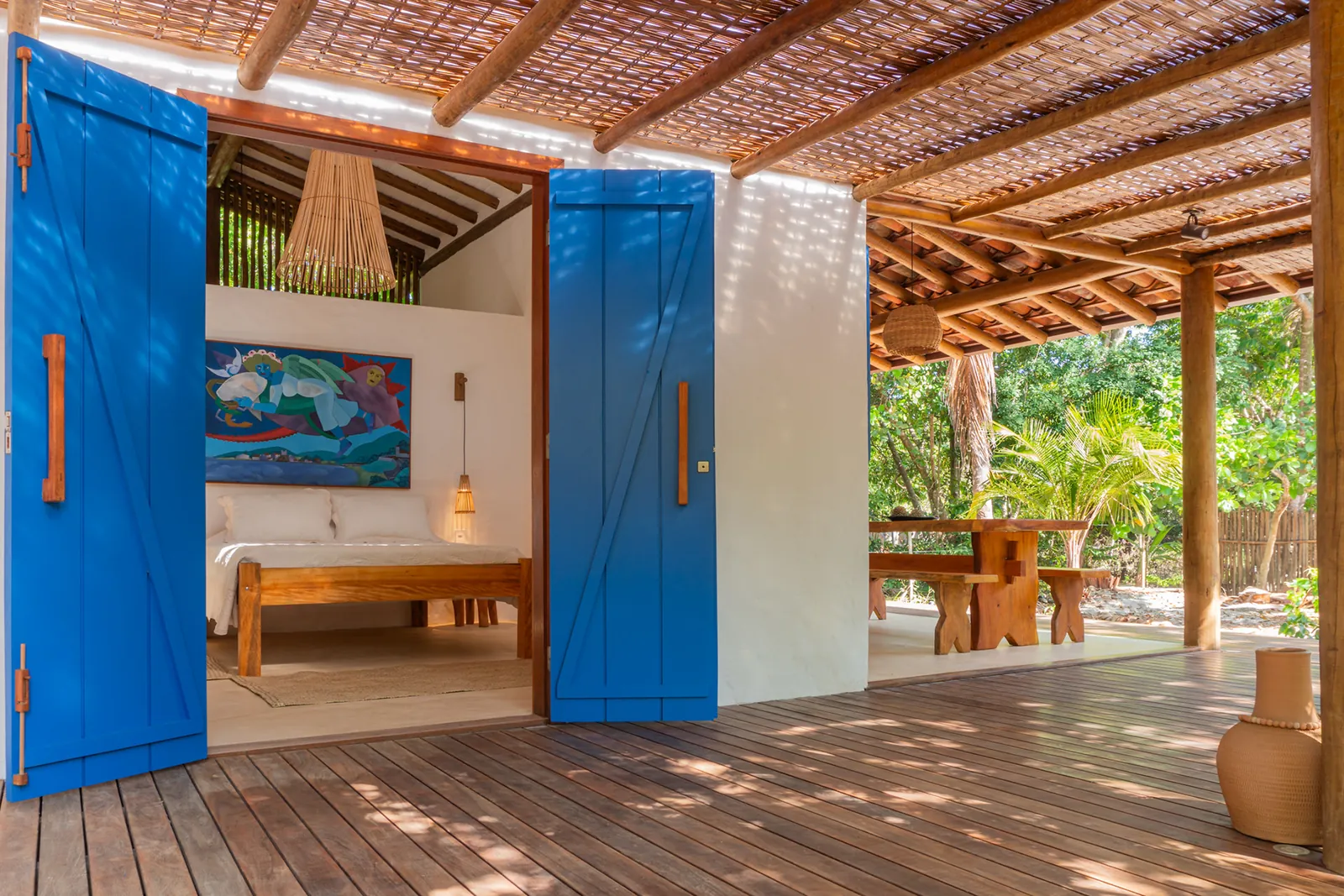 Quarto aberto para varanda com portas azuis