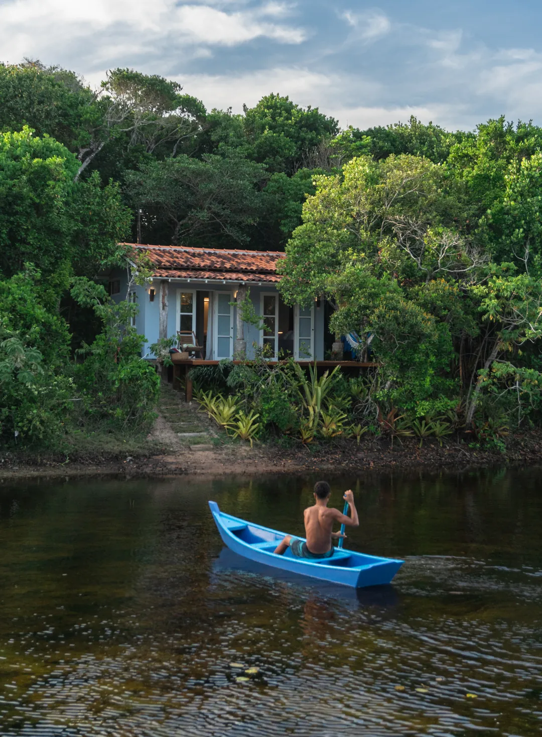 Canoa no rio diante de casa entre árvores