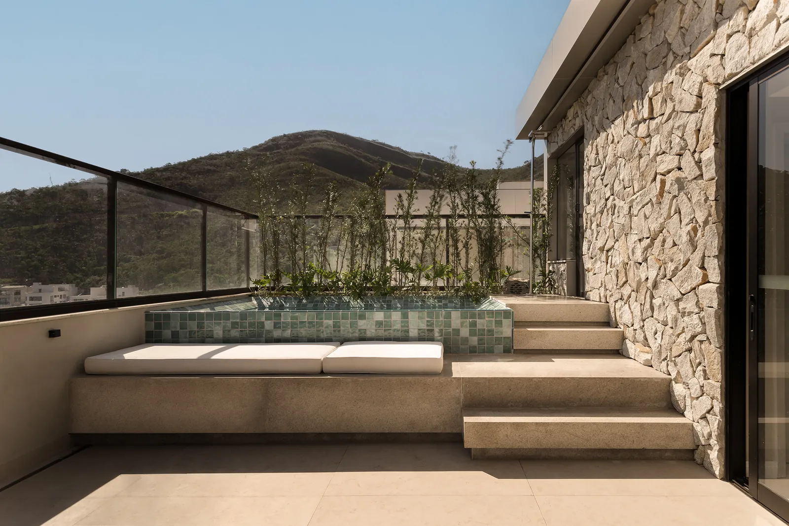 Terraço com banco de pedra e vista para a serra