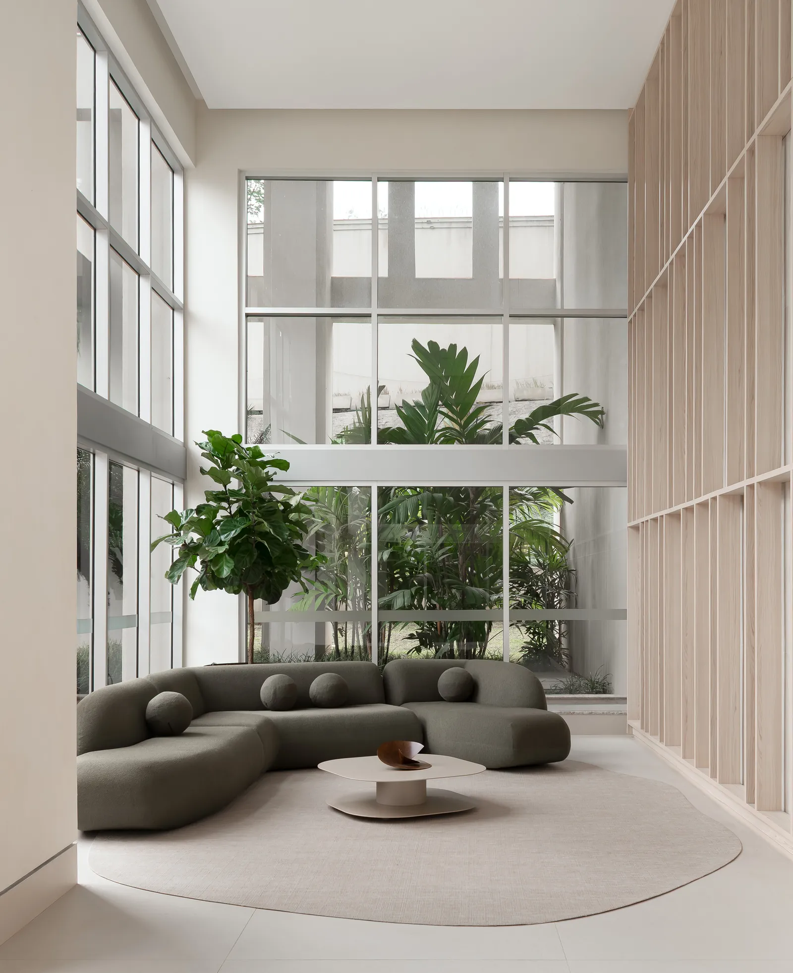 Sala de pé-direito duplo com sofá curvo