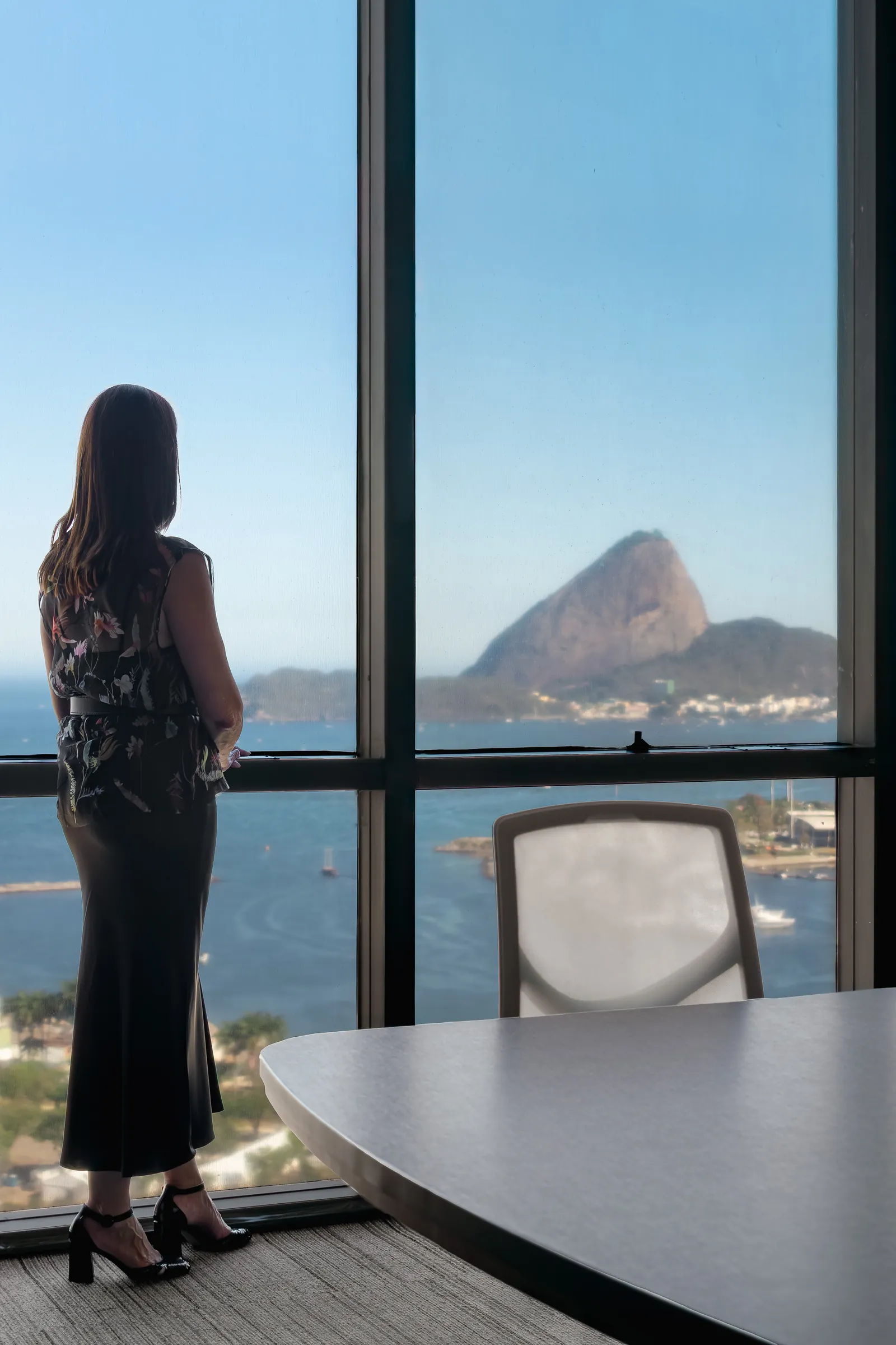 Mulher diante da janela com vista para o Pão de Açúcar