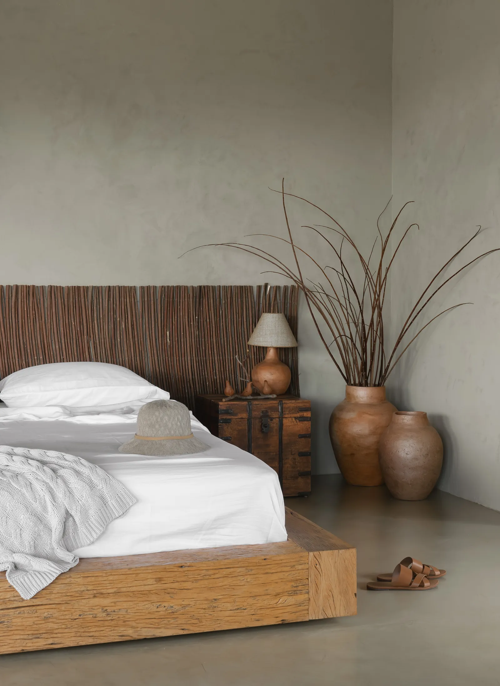 Quarto com cama baixa e vasos de cerâmica