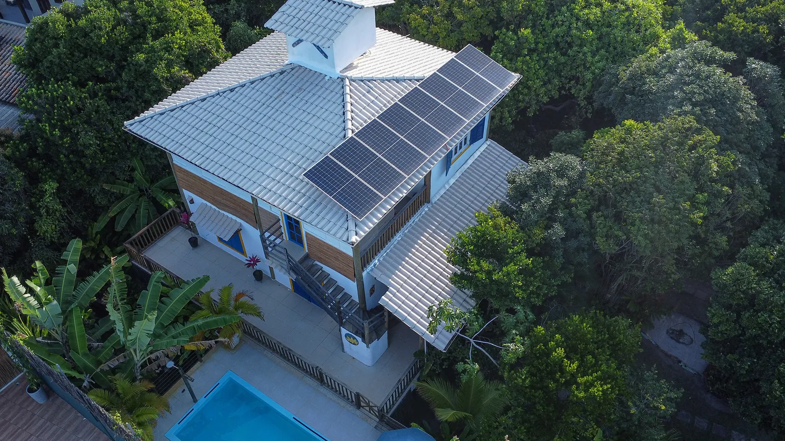 Vista aérea de casa com piscina na mata