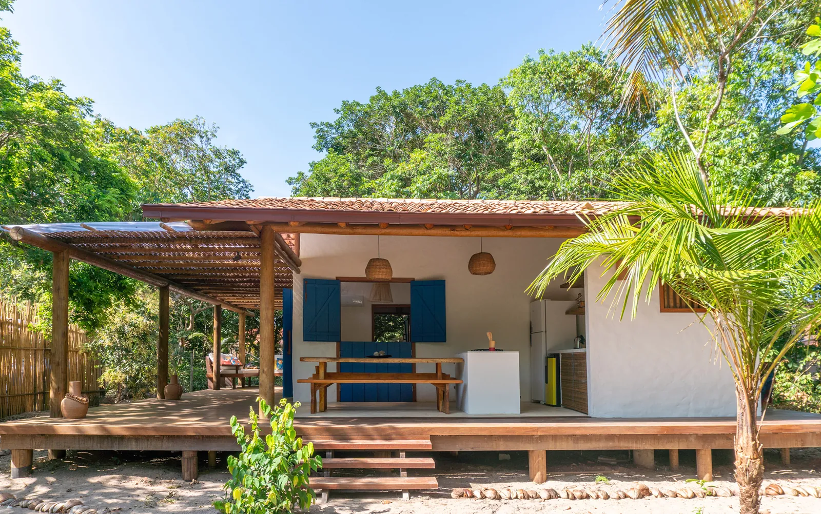 Casa de praia com varanda de madeira e portas azuis